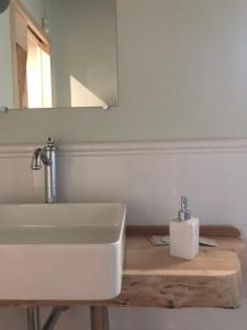 y baño con lavabo blanco y espejo. en B&B BAGOLARI, en Villaganzerla