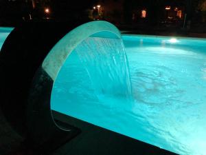 una fuente de agua en una piscina por la noche en B&B BAGOLARI, en Villaganzerla