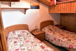 a bedroom with two beds in a room at Mansarda Caviola in Falcade