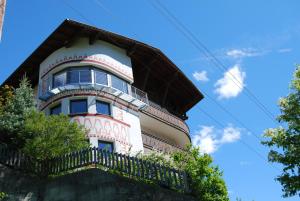 a pink and white building with a balcony at Apart Stotter in Kappl