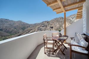 a balcony with two chairs and a table with a view at Shizen Houses in Serifos Chora