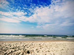 piaszczysta plaża z falami w oceanie w obiekcie Dom na Błękitnej w Karwieńskim Błocie