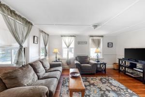 een woonkamer met een bank en een tv bij Parkview Cottage in Bar Harbor