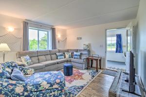 a living room with a couch and a tv at Cozy Central Lake Cottage about 3 Mi to Lake Michigan! in Central Lake