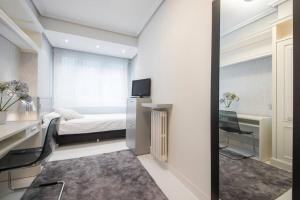 a small bedroom with a bed and a desk and a mirror at BELLA VISTA LUXURY APARTMENT. BAY VIEWS. PARKING in San Sebastián