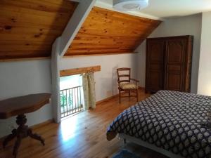 a bedroom with a bed and a chair and a window at Domaine du Haul - Gîte Le Pressoir in Catteville