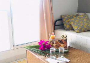 een tafel met eten en bloemen erop bij Charmant studio Kannèl au MANGANAO vue sur mer et panier d'accueil offert in Saint-François