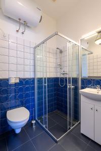 y baño con ducha, aseo y lavamanos. en Komodora nams en Liepāja