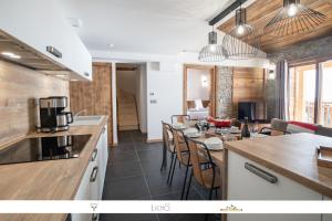 een keuken en eetkamer met een tafel en stoelen bij MARMOTTE 204 - Charmant appartement mansardé, aux pieds des pistes in Bonneval-sur-Arc