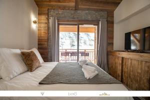 een slaapkamer met een bed met een teddybeer erop bij MARMOTTE 204 - Charmant appartement mansardé, aux pieds des pistes in Bonneval-sur-Arc