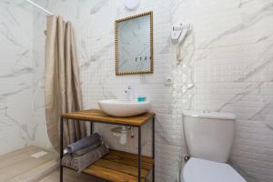 a white bathroom with a sink and a toilet at Hotel Loft Кароліно-Бугаз in Zatoka