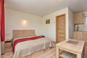 a bedroom with a bed and a wooden table at Vila Tante in Šventoji