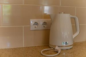 a white blender sitting on top of a counter at Komodora nams in Liepāja