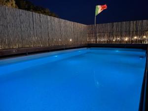 a flag flying over a swimming pool at night at La casa di Colino e Annina in Monopoli