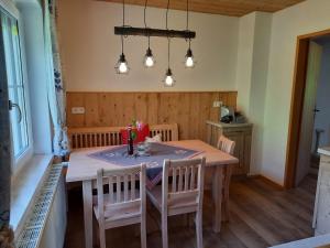 a dining room with a table and chairs and lights at Naturidyll Brunner in Köstendorf