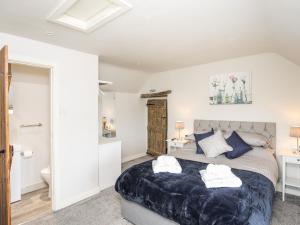 a bedroom with a large bed and a bathroom at Hafotty Gelynen in Corwen