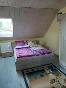 1 dormitorio con 1 cama con sábanas moradas en Pod żurawiem Szwałk 1 en Swiętajno