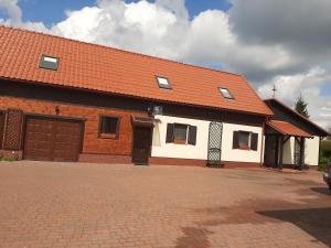 een groot bakstenen gebouw met een oranje dak bij Pod żurawiem Szwałk 1 in Swiętajno