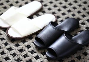 a pair of black slippers and a pair of white shoes at APA Hotel Yodoyabashi Kitahama Ekimae in Osaka