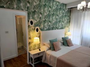 a bedroom with a bed and a wall with leaves at Casa castro in Cruces +23 photos