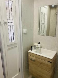 a bathroom with a white sink and a mirror at Litharaki Guest House in Ano Syros