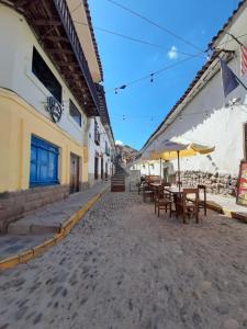 un callejón con mesas y sombrillas en una calle en La Casa de Laura, en Cusco