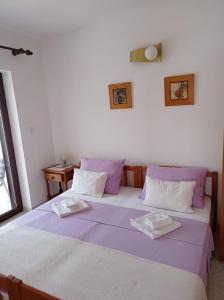 a bedroom with a large bed with purple and white pillows at "Sunny" - Studio Apartment in Pula