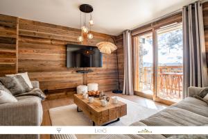 a living room with a couch and a table at Marmotte 103 - Luxueux appartement aux pieds des pistes in Bonneval-sur-Arc