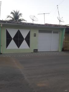 a house with a garage with black and white at Pedacinho do Toque in São Miguel dos Milagres