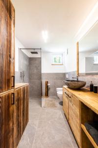 a bathroom with a sink and a toilet and a shower at Sa Mont Home - Moderno appartamento con parcheggio, sauna e deposito sci in Bellamonte