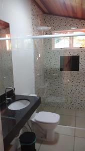 a bathroom with a white toilet and a sink at Sitio Espelho Dagua - Brotas SP in Brotas