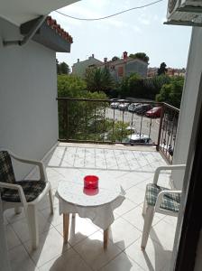a balcony with a red bowl on a table and chairs at "Sunny" - Studio Apartment in Pula