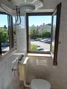 a bathroom with a toilet and a window at "Sunny" - Studio Apartment in Pula