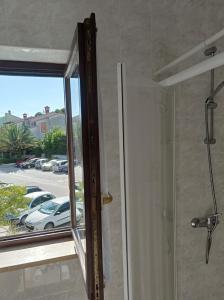 a shower with a glass door and a window at "Sunny" - Studio Apartment in Pula