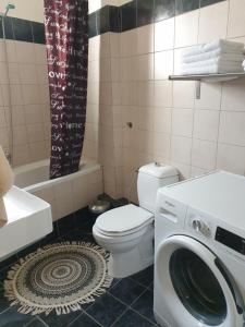 La salle de bains est pourvue de toilettes et d'un lave-linge. dans l'établissement Comfortable apartment in the center of Volos very close to the port, à Vólos