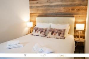 una camera con un letto bianco e 2 lampade di MARMOTTE 004 - Charmant appartement pour 6, aux pieds des pistes a Bonneval-sur-Arc