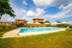 蒙特普齐亚诺Tuscany Living - Terra Antica的房子旁边有带椅子和遮阳伞的游泳池