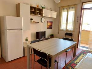 cocina con mesa de madera y nevera en Luisa 5B, en Lido di Pomposa