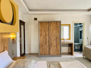 Akçahan Apart Hotel في أنطاليا: غرفة نوم فيها باب خشبي وحمام