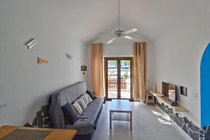 ein Wohnzimmer mit einem Sofa und einem Tisch in der Unterkunft Casa Maria N2 Montecastillo in Caleta de Fuste