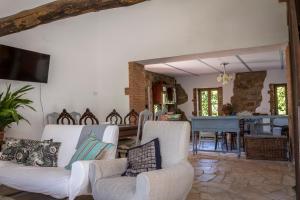 uma sala de estar com dois sofás brancos e um piano em Casa Rural Castillo JABUGO em Jabugo