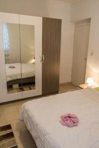 a bedroom with a white bed and a mirror at Apartment in Mundanije with balcony, air conditioning, WiFi, washing machine (4912-3) in Mundanije