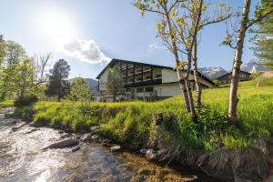 ein Haus auf einem Hügel neben einem Fluss in der Unterkunft Berg & Bett Säntis Lodge in Unterwasser