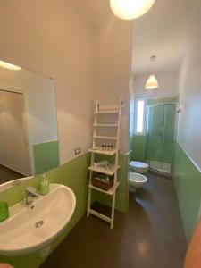La salle de bains est pourvue d'un lavabo, de toilettes et d'un miroir. dans l'établissement Il Veliero, à Polignano a Mare