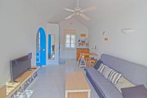 a living room with a blue couch and a table at Casa Maria N2 Montecastillo in Caleta De Fuste