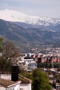 vistas a una ciudad con montañas cubiertas de nieve en casa carmen alhambra, en Granada