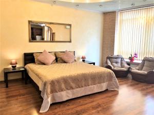 ein Schlafzimmer mit einem großen Bett und einem Spiegel in der Unterkunft VIP апартаменти з видом на озеро in Kiew