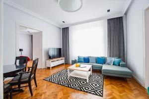 una sala de estar con un sofá y una mesa en Spacious RiverViews Apartment near Piata Unirii, en Oradea