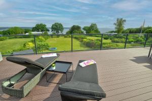 eine Terrasse mit einem Tisch und Stühlen auf einer Terrasse in der Unterkunft fewo1846 - Sundowner - luxuriöse Wohnung mit 2 Schlafzimmern und Sonnenterrasse in Flensburg
