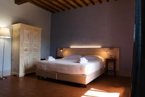a bedroom with a large bed and a wooden headboard at Paradiso in Chianti in Gaiole in Chianti